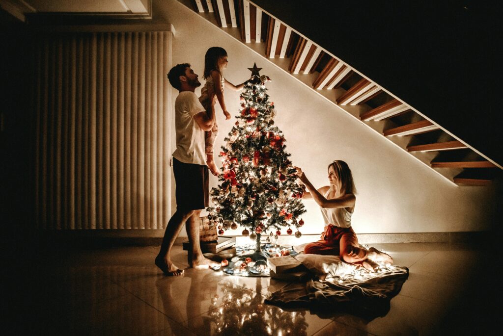 A family decorates a Christmas tree, bringing warmth and joy to the holiday season.